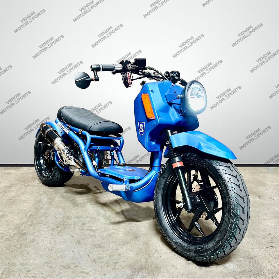A blue mini motorbike with black wheels, a black seat, and chrome exhaust pipes, photographed in a studio setting with a gray background and repeating 'VENOM MOTORSPORTS' watermarks.